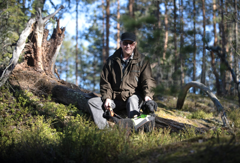 Mies ja villakoira metsässä